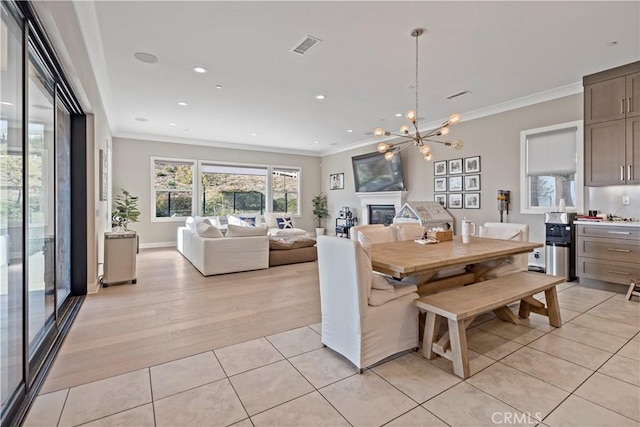 dining room featuring crown molding, light tile patterned flooring, and a chandelier