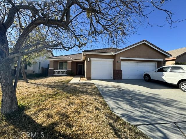 ranch-style house with a garage and a front lawn