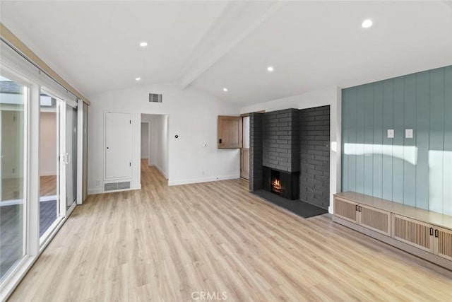 unfurnished living room with lofted ceiling with beams, light hardwood / wood-style floors, and a brick fireplace