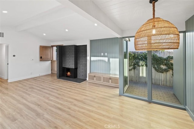 unfurnished living room featuring lofted ceiling with beams, light hardwood / wood-style floors, and a fireplace