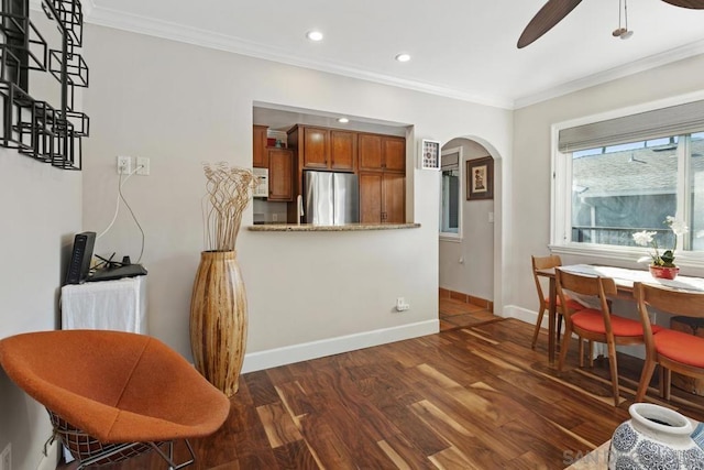 kitchen with crown molding, ceiling fan, dark hardwood / wood-style flooring, kitchen peninsula, and stainless steel refrigerator