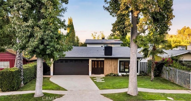 view of front of property featuring a lawn and a garage