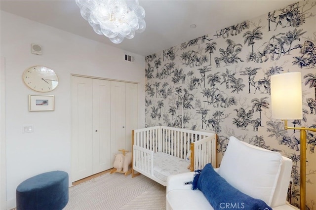 bedroom with an inviting chandelier, a closet, and a nursery area