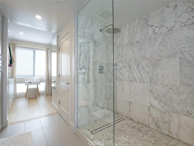 bathroom with tile patterned flooring and tiled shower