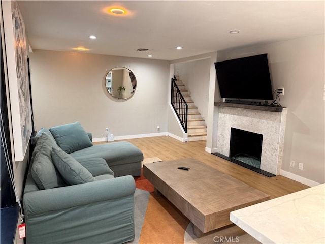 living room with hardwood / wood-style flooring and a tile fireplace