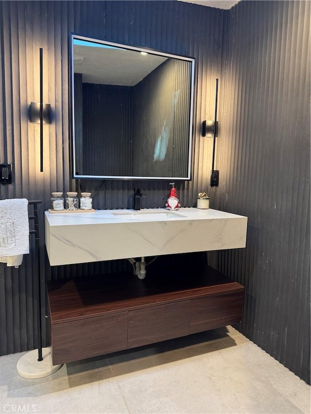 bathroom with tile patterned flooring, sink, and wooden walls