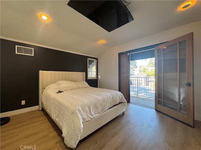 bedroom featuring hardwood / wood-style flooring, multiple windows, and access to outside