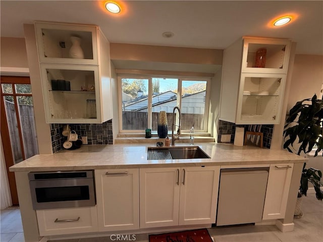 kitchen featuring white cabinetry, sink, and backsplash