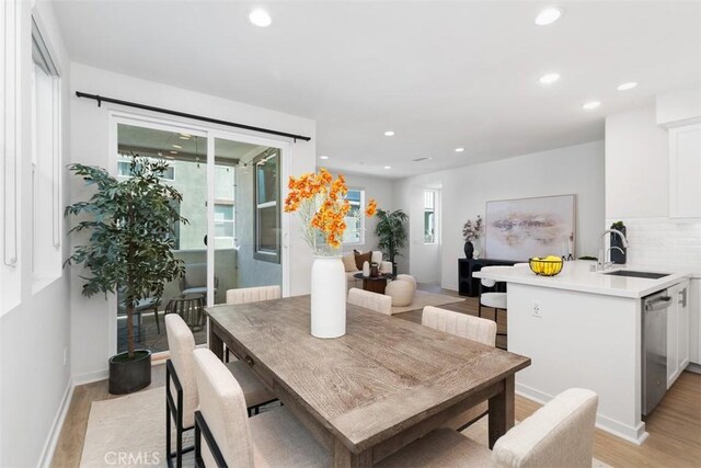 dining area featuring light wood-type flooring and sink