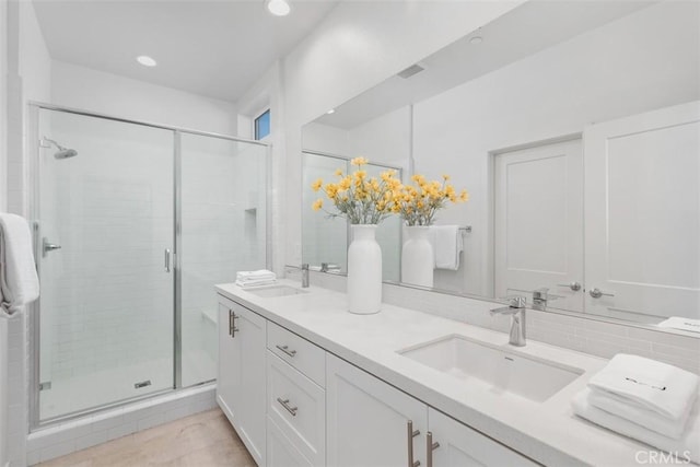 bathroom featuring vanity and a shower with door