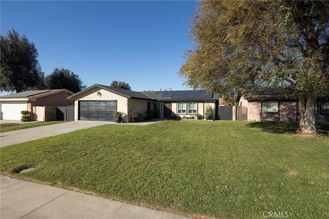 single story home with a garage, a front yard, and solar panels