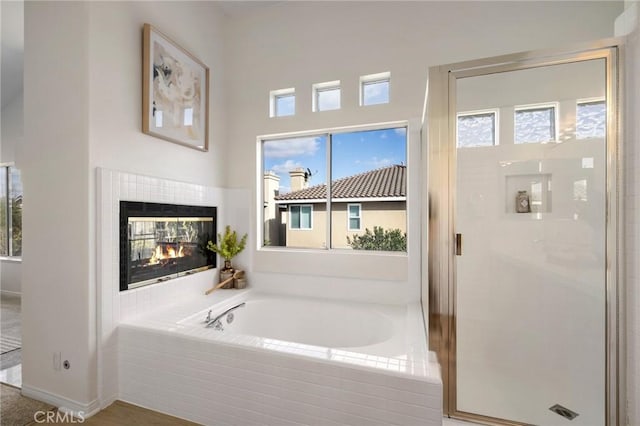 bathroom with plus walk in shower and a tiled fireplace