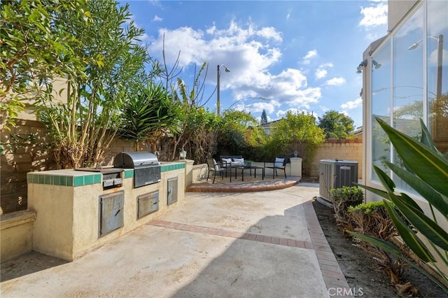 view of patio with area for grilling, exterior kitchen, an outdoor living space, and cooling unit