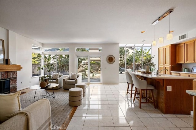 tiled living room featuring sink and a fireplace