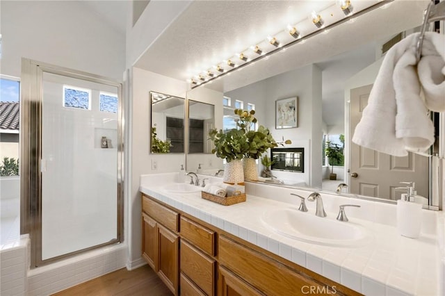 bathroom featuring an enclosed shower, vanity, and wood-type flooring