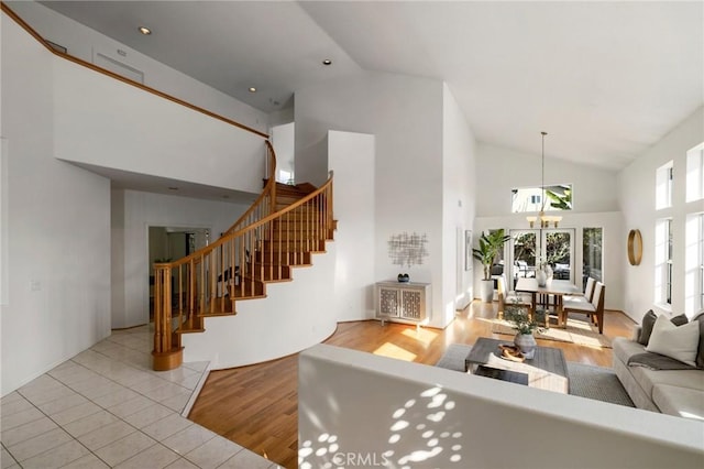 tiled living room with a towering ceiling and a notable chandelier