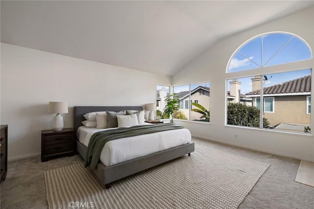 bedroom featuring carpet, multiple windows, and lofted ceiling