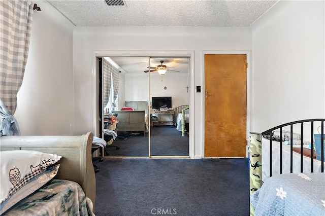 bedroom with a textured ceiling, a closet, carpet flooring, and ceiling fan