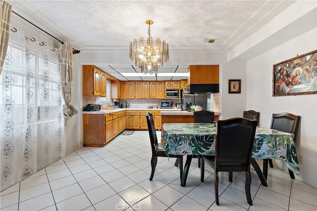 tiled dining space featuring a textured ceiling and a notable chandelier