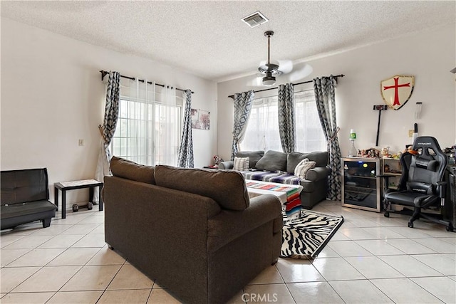 tiled living room featuring a textured ceiling and ceiling fan