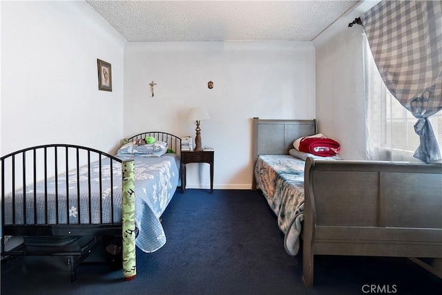 bedroom with a textured ceiling and dark colored carpet