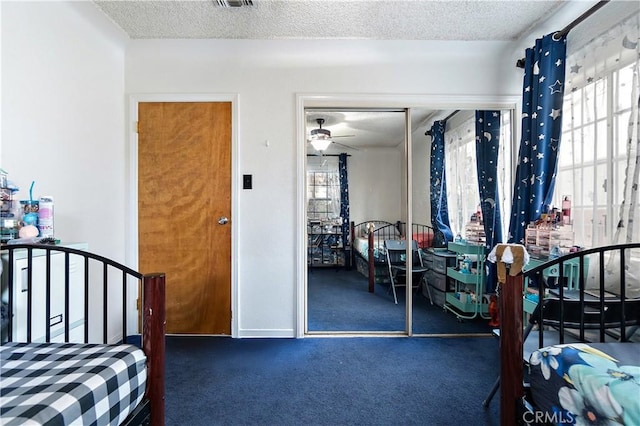 carpeted bedroom featuring a textured ceiling and a closet