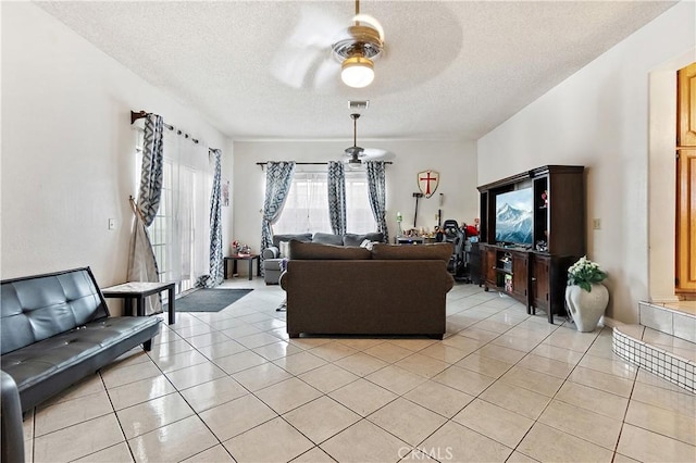 tiled living room featuring a textured ceiling and ceiling fan