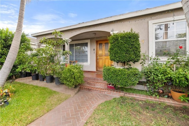 view of exterior entry with a yard