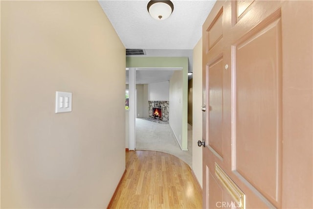 hall featuring a textured ceiling and light wood-type flooring