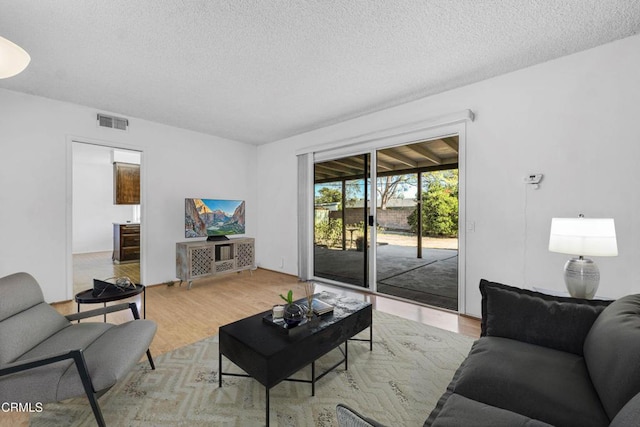 living room with hardwood / wood-style flooring, a textured ceiling, and wine cooler