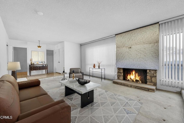 living room featuring carpet floors, a textured ceiling, and a fireplace