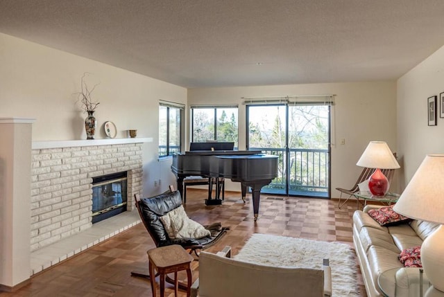 living room with a brick fireplace, a textured ceiling, and parquet flooring