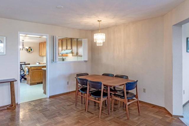 dining space featuring parquet floors and a notable chandelier