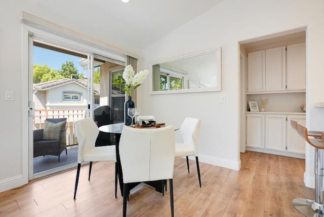 dining room featuring lofted ceiling and light wood-type flooring