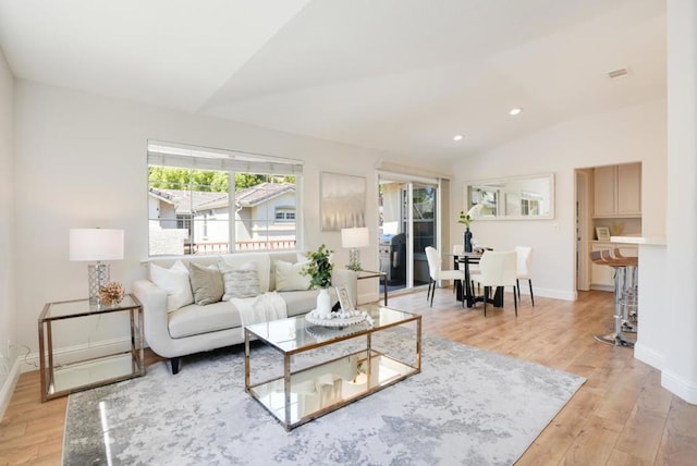 living room with light wood-type flooring and lofted ceiling