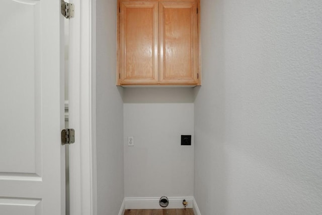 laundry area featuring hardwood / wood-style flooring, cabinets, and electric dryer hookup