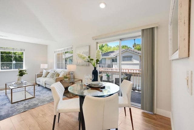 dining space featuring lofted ceiling and light hardwood / wood-style flooring