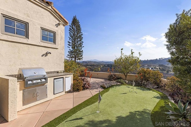 view of yard with a patio, a mountain view, and area for grilling