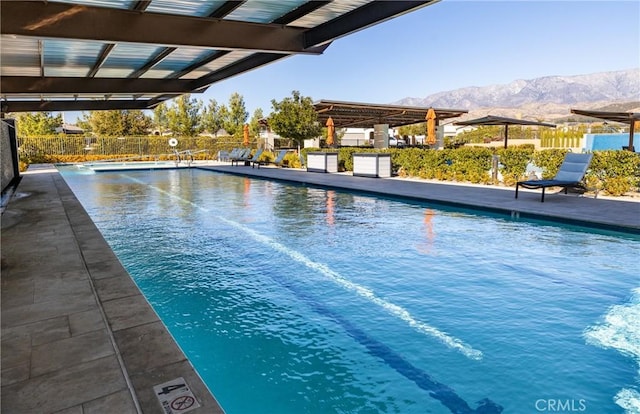 view of pool with a mountain view and a pergola