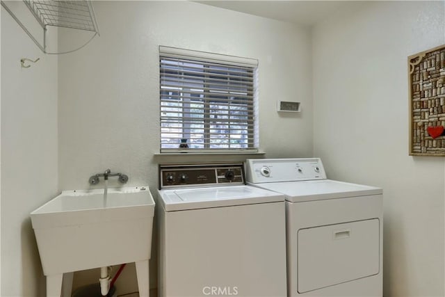 laundry room with separate washer and dryer and sink