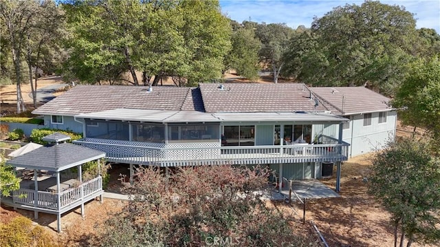 rear view of house featuring a deck and a sunroom