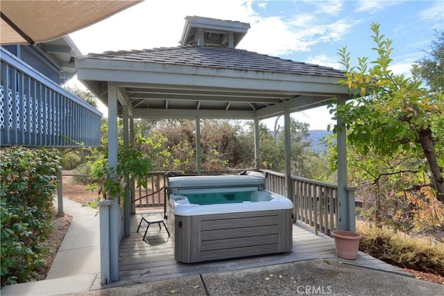 view of patio / terrace featuring a gazebo, a wooden deck, and a hot tub