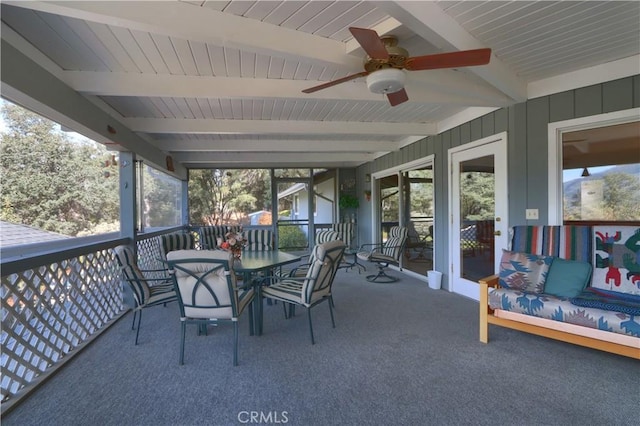 sunroom / solarium featuring ceiling fan and beamed ceiling