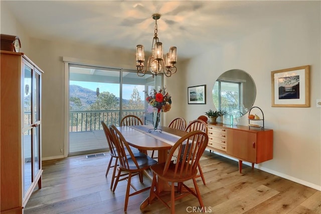 dining room with an inviting chandelier and light hardwood / wood-style flooring