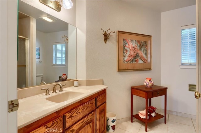 bathroom with tile patterned flooring, vanity, toilet, and plenty of natural light