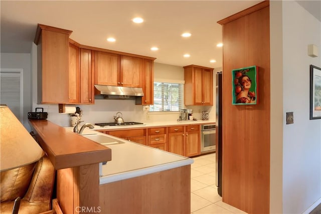 kitchen featuring stainless steel oven, sink, light tile patterned floors, kitchen peninsula, and gas cooktop