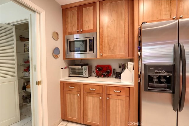 kitchen with light tile patterned floors and stainless steel appliances