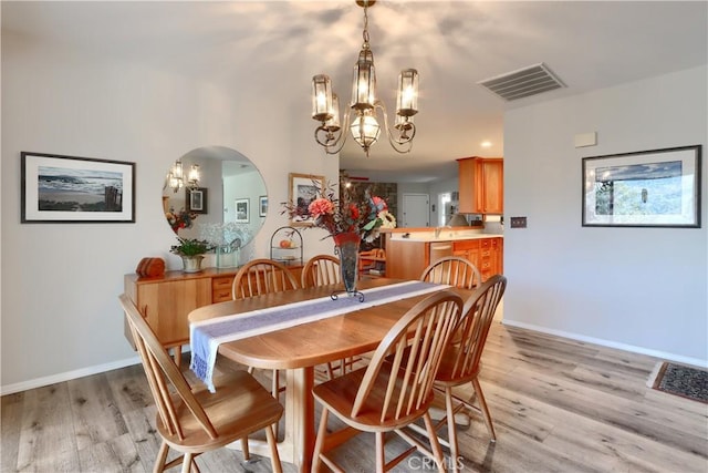 dining room with a chandelier and light hardwood / wood-style floors