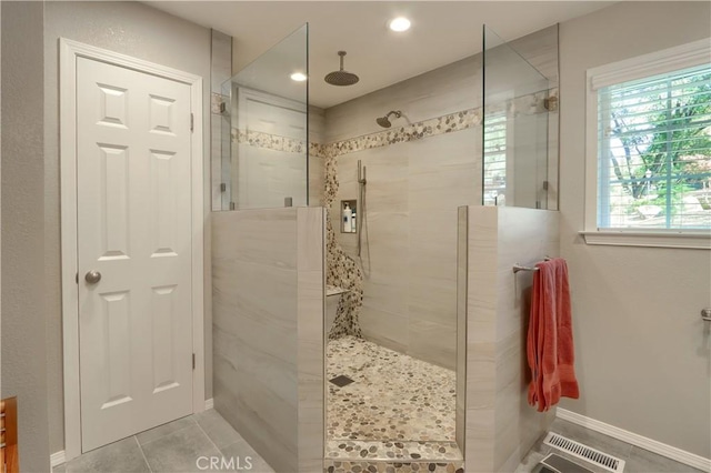 bathroom featuring tiled shower and tile patterned floors