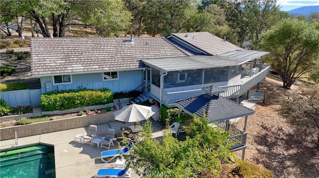 back of house with a fenced in pool, a pergola, a sunroom, and a patio